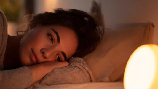 Person calming their mind before bed with soft light and relaxed posture