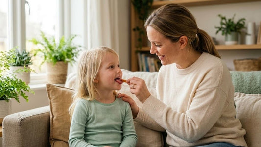 Parent placing a dye-free, children's fever reducer oral dissolving strip on a young child's tongue.