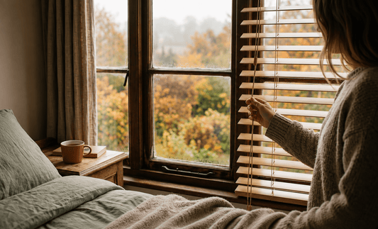  Bedroom window with a person adjusting the blinds in early morning autumn light 