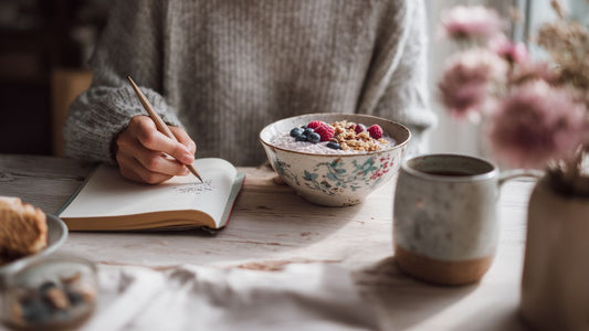 Person holding a warm mug in a cozy winter kitchen while preparing a fiber-rich snack