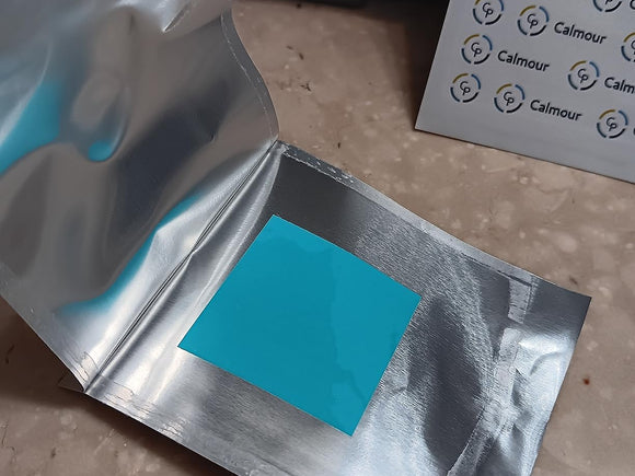 An opened foil sachet with the mint strip inside