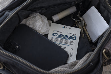 A Calmour sachet among keys, a phone and a tissue inside a handbag