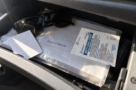 A Calmour sachet on the owner&rsquo;s manual in an open car glovebox