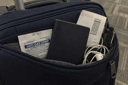 A Calmour sachet in a carry-on pocket beside a passport and a boarding pass