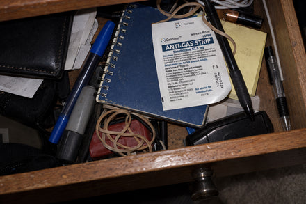 A Calmour sachet in an open desk drawer among pens and elastic bands