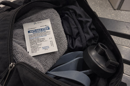 A Calmour sachet resting on a rolled towel inside an open gym bag